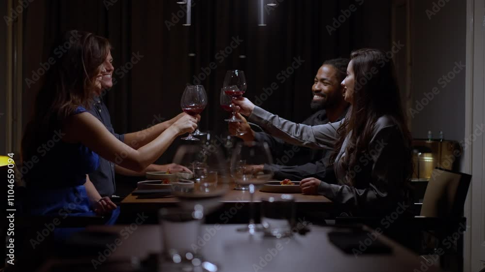A group of friends joyfully toasting with wine glasses at a cozy dinner gathering, surrounded by warm lighting and an inviting atmosphere A group of friends joyfully toasting with wine glasses at a cozy dinner gathering, surrounded by warm lighting and an inviting atmosphere