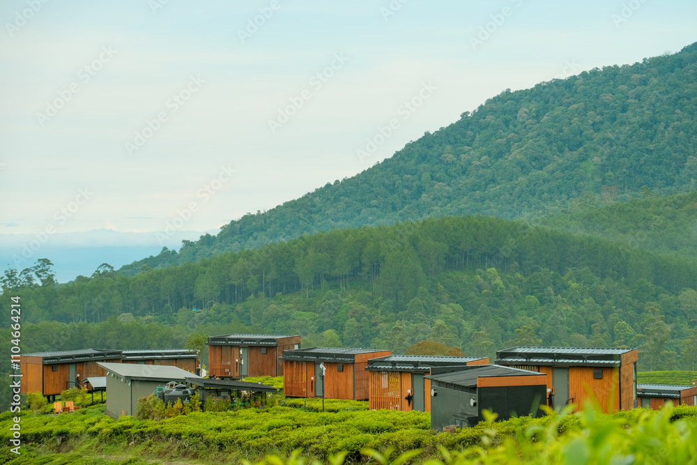 Scenic wooden cabins nestled in lush greenery with a mountainous backdrop. Scenic wooden cabins nestled in lush greenery with a mountainous backdrop.