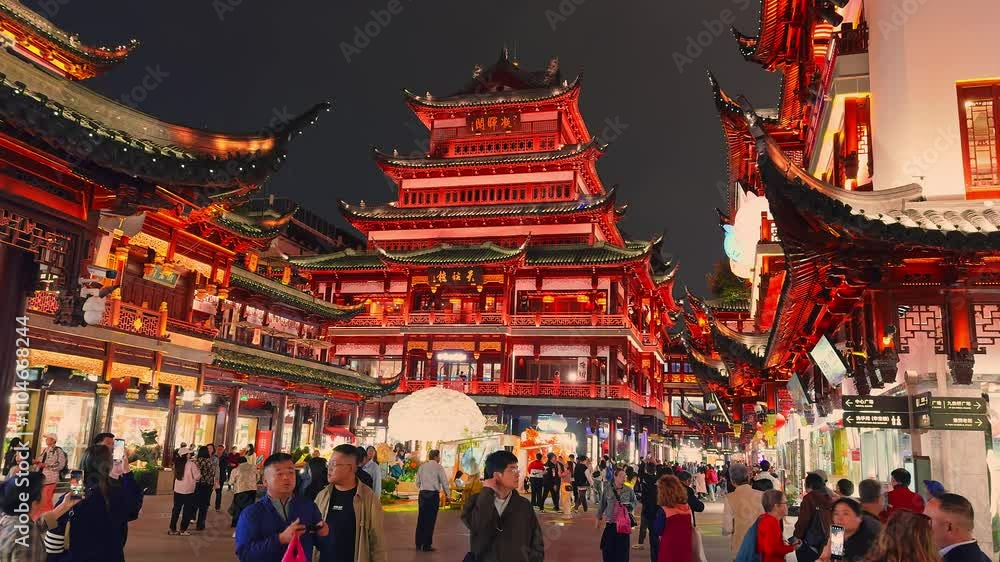 Yu Gardens in Shanghai is illuminated with red and gold lights, showcasing traditional architecture and bustling crowds in a festive atmosphere.