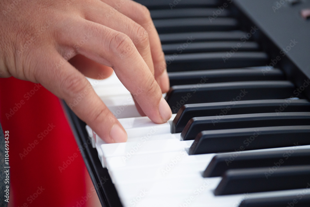 Fototapeta premium hands of a child playing the piano,Close-up of a musician's hands playing a piano or keyboard.
