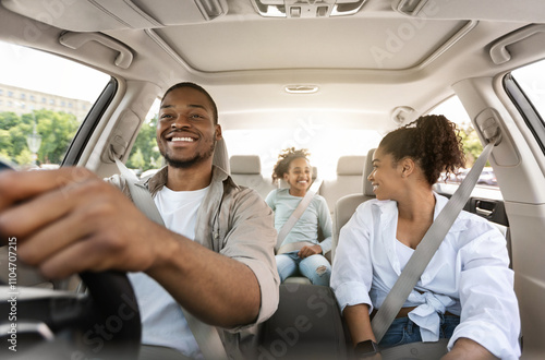 Happy African American Family Driving New Automobile Having Ride In City, Enjoying Road Trip. Parents And Daughter Spending Vacation Traveling By Car. Auto Purchase And Rent. Selective Focus