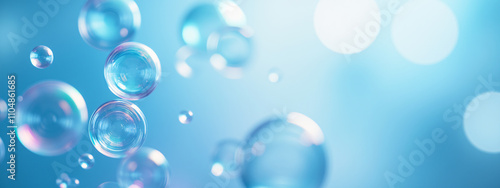 A close-up view of translucent bubbles floating against a soft blue background, creating a clean and refreshing aesthetic for design elements.