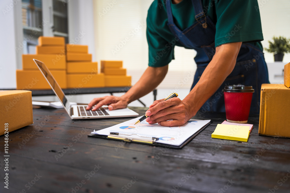 Close-up of a businessman’s hand packing items at a desk, preparing products for shipping. Highlighting delivery services for private companies online shopping with credit cards for convenience Close-up of a businessman’s hand packing items at a desk, preparing products for shipping. Highlighting delivery services for private companies online shopping with credit cards for convenience