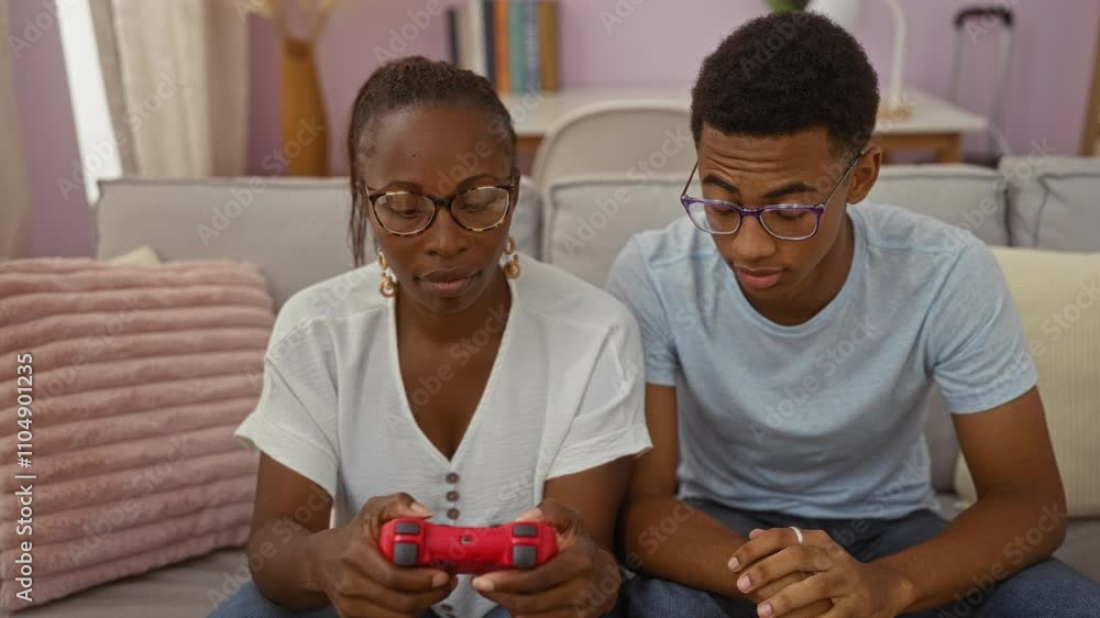 Son teaching mother how to use video game controller in cozy living room, showcasing family bonding inside an apartment Son teaching mother how to use video game controller in cozy living room, showcasing family bonding inside an apartment