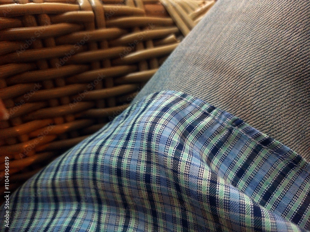 Close-up view of a denim fabric, with a focus on its texture and weave. The material is blue denim, with visible diagonal lines typical of the twill weave used in jeans. Textured background Close-up view of a denim fabric, with a focus on its texture and weave. The material is blue denim, with visible diagonal lines typical of the twill weave used in jeans. Textured background
