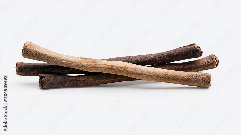 Three dried cinnamon sticks lie on a white background. Three dried cinnamon sticks lie on a white background.