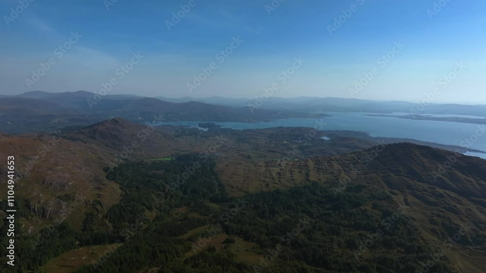 Coomarkane, Caha Mountains, County Cork, Ireland, September 2024. Drone slowly pushes east toward Furkeal in a stunning aerial vista of the landscape with planted forest and the North Atlantic Ocean. Coomarkane, Caha Mountains, County Cork, Ireland, September 2024. Drone slowly pushes east toward Furkeal in a stunning aerial vista of the landscape with planted forest and the North Atlantic Ocean.