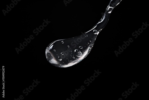 Liquid Droplet Falling Against Black Background photo