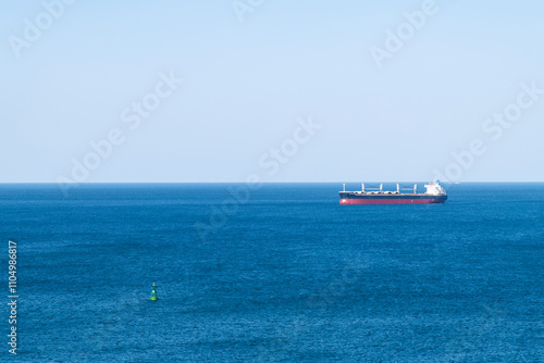 floating buoy and cargo ship on the sea photo