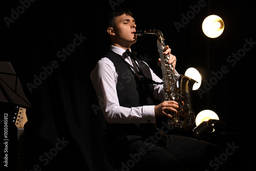 Photography Male artist playing saxophone on dark background