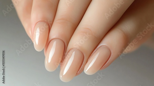 Close up of a woman's hand with soft, neutral nail polish.