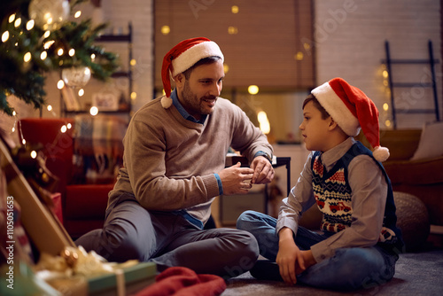 Smiling father and son talking during Christmas Eve at home. photo