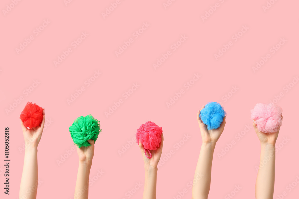 Female hands with different bath sponges on pink background Female hands with different bath sponges on pink background