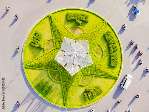 A difficult road intersection.

A drone shot from above of the intersection in Nha Trang in Vietnam of 7 roads. In the center of the intersection there is a flower bed in the shape of a star and a lig