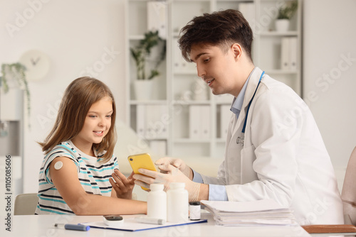 Diabetic girl with glucose sensor and doctor measuring blood sugar level in clinic