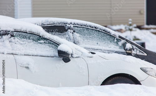 Two cars are covered in snow and have their windows frosted over photo