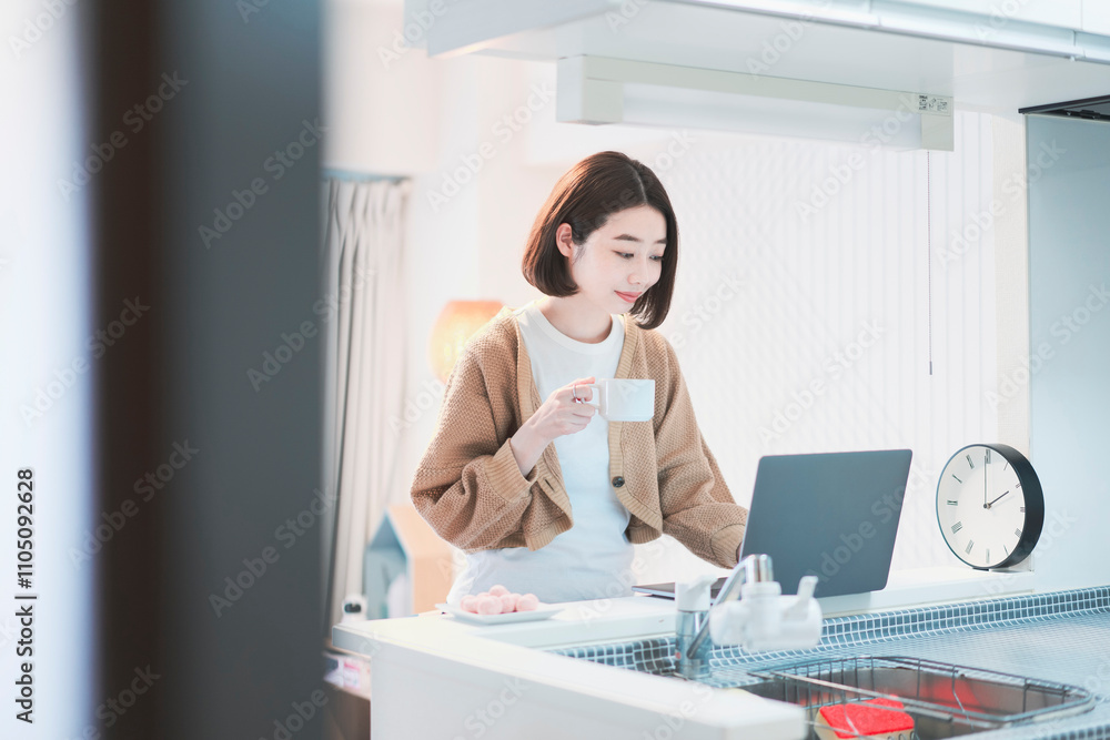 Obraz premium ドリンクを手にして在宅で仕事をする女性