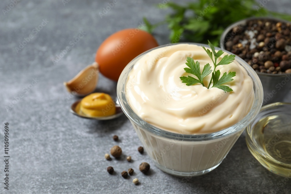 Bowl with mayonnaise and ingredients for cooking on gray background Bowl with mayonnaise and ingredients for cooking on gray background