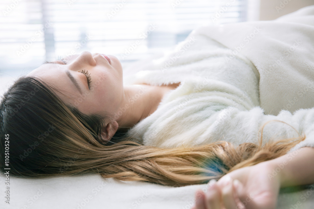 白いベッドで眠る女性 白いベッドで眠る女性