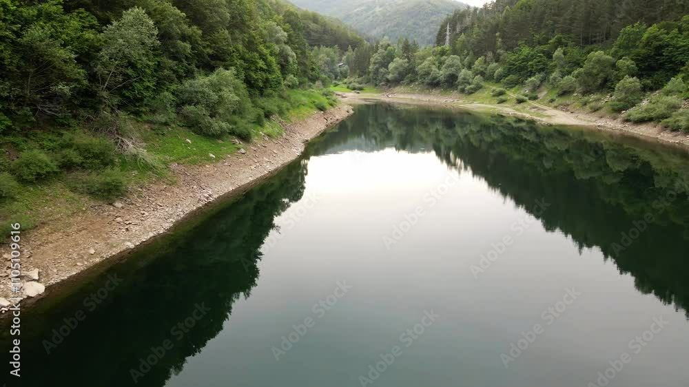 Calm river surrounded by lush greenery in a serene mountain landscape during early morning Calm river surrounded by lush greenery in a serene mountain landscape during early morning