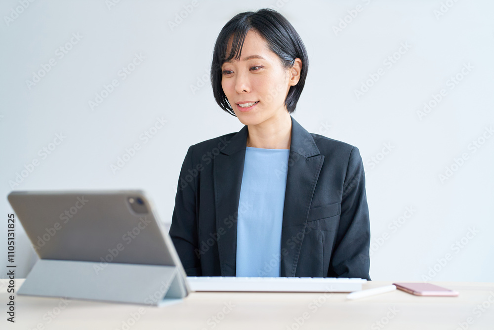 タブレットPCを使って、オンラインコミュニケーションをするビジネスウーマン タブレットPCを使って、オンラインコミュニケーションをするビジネスウーマン