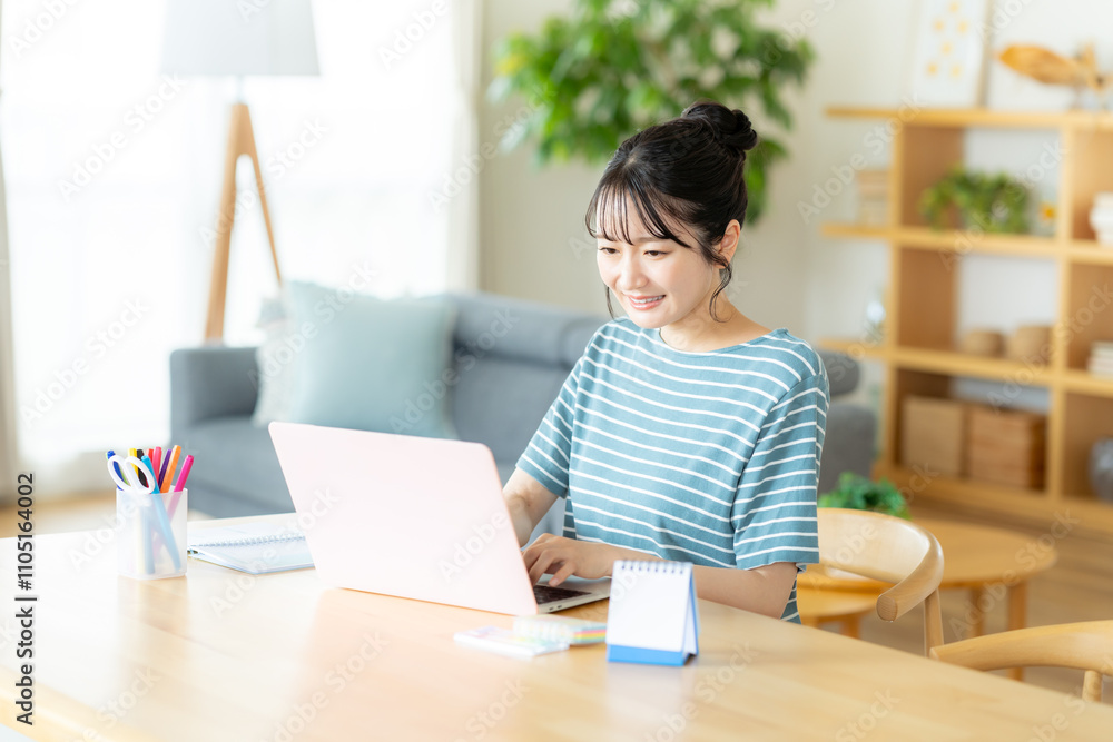 リビングでノートパソコンを操作する女性 リビングでノートパソコンを操作する女性