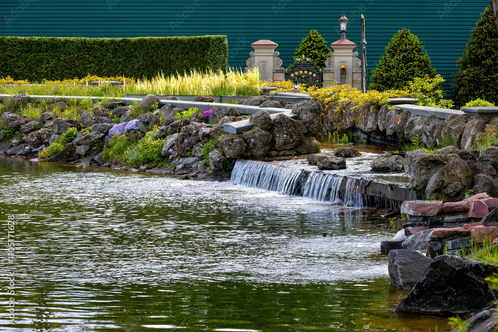 Tranquil waters cascade gently through a lush garden paradise in summer