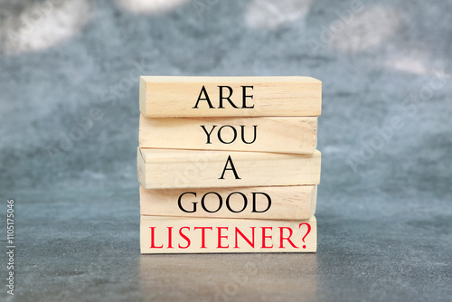 Listening skills symbol written on Wooden blocks with words Are you a good Listener. Beautiful grey background. Business and Are you a good Listener concept. Copy space.