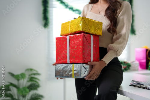 Confident Asian girl holding Christmas gift box in Santa hat smiling and holding presents. Christmas shopping and event ideas Celebration day during long holiday, party. photo