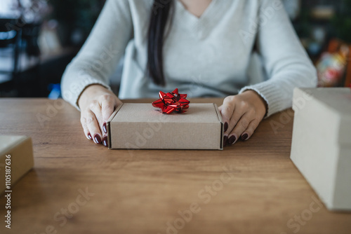 woman hold gift with red ribbon for Christmas on wooden table photo