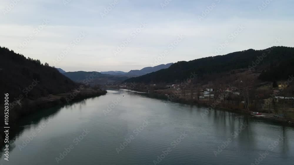 Serene river landscape with mountains and forest under clear sky in rural area Serene river landscape with mountains and forest under clear sky in rural area