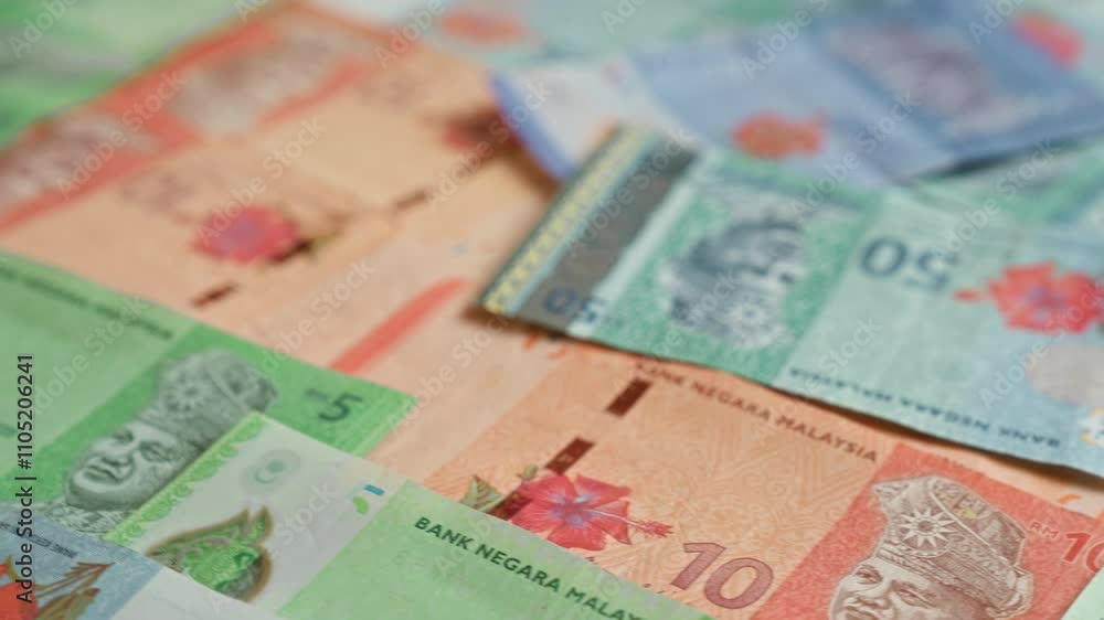 Various malaysian banknotes including 5, 10, and 50 ringgit denominations scattered in a close-up view showcasing the vibrant designs and colors of malaysia's currency. Various malaysian banknotes including 5, 10, and 50 ringgit denominations scattered in a close-up view showcasing the vibrant designs and colors of malaysia's currency.