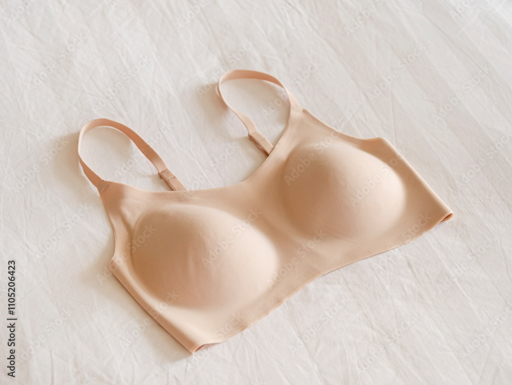 beige seamless bra isolated on hotel bed. Comfortable beige brassiere for sport, fit woman underclothes beige seamless bra isolated on hotel bed. Comfortable beige brassiere for sport, fit woman underclothes