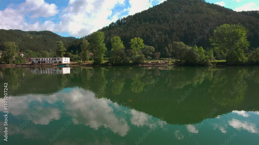 Tranquil lake surrounded by mountains with reflections and lush greenery in a serene landscape Tranquil lake surrounded by mountains with reflections and lush greenery in a serene landscape