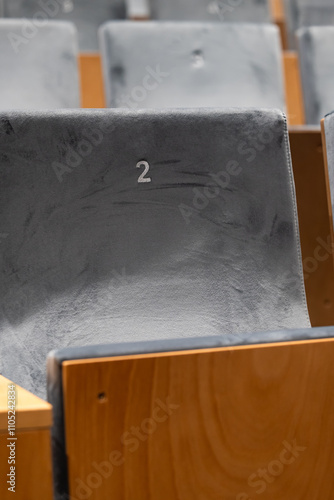 Obraz na płótnie Rows of empty seats in a cinema hall, front side of the seats with numbers. Close-up with shallow depth of field w salonie