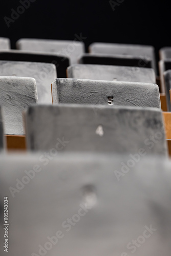 Obraz na płótnie Rows of empty seats in a cinema hall, front side of the seats with numbers. Close-up with shallow depth of field w salonie
