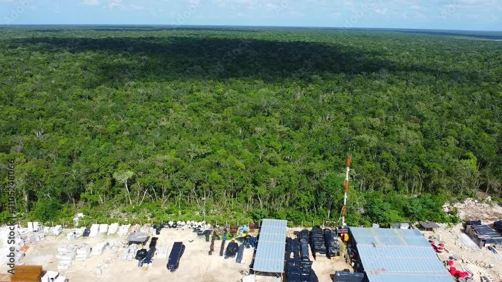 Dense green jungle stretching to the horizon, with industrial equipment and structures in the foreground. Dense green jungle stretching to the horizon, with industrial equipment and structures in the foreground.