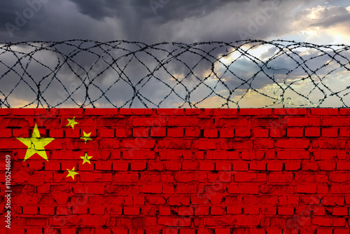 Photography The flag of the country of China, on a wall of bricks with barbed wire, against a backdrop of a stormy sky