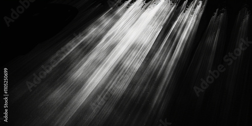 Black and white abstract image of light streaks with a dark background.