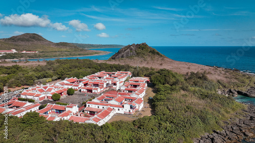 Scenic view of Kenting Baishawan coastline with colorful buildings and nearby mountains photo