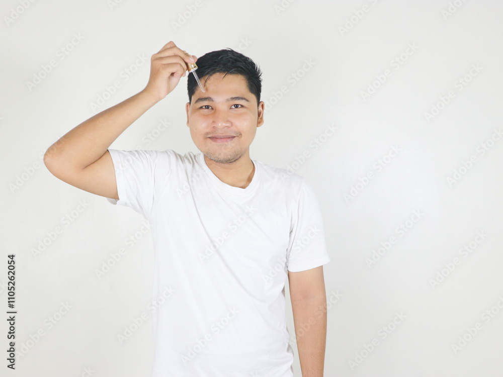 portrait of handsome guy applying serum beauty product on his face using glass pipette portrait of handsome guy applying serum beauty product on his face using glass pipette