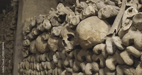 Ancient Human Skulls and Bones Arranged in Historic Paris Catacombs Underground Ossuary. Haunting Close-up Documentary Footage of Famous French Underground Cemetery with Authentic Medieval Remains