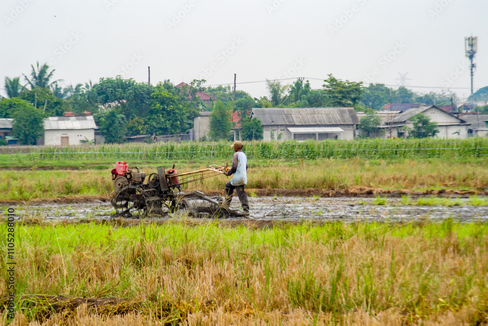 Obraz premium Farmer plows a field with a tractor