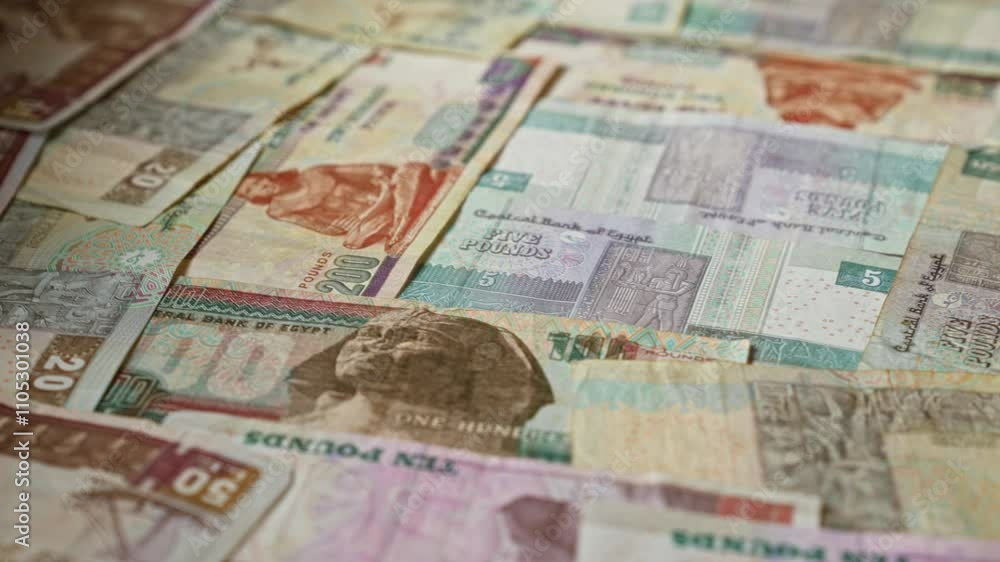 Egyptian banknotes of different denominations scattered in a random arrangement, showcasing colorful currency details with emphasis on egyptian pounds and historical figures. Egyptian banknotes of different denominations scattered in a random arrangement, showcasing colorful currency details with emphasis on egyptian pounds and historical figures.