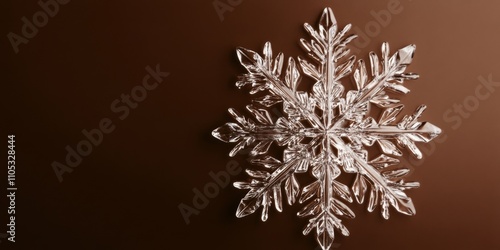 Glass snowflake displayed against a brown background, highlighting the intricate details and beauty of the glass snowflake design, perfect for festive or winter themed collections.