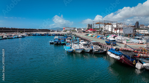 Fishing boats docked at the busy harbor in Hualien, Taiwan under a clear blue sky in daytime