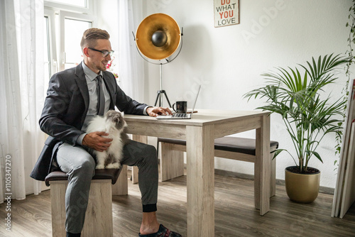 Junger Mann im Homeoffice Arbeiten am Schreibtisch Laptop konzentriert produktiv im modernen Homeoffice Umfeld photo