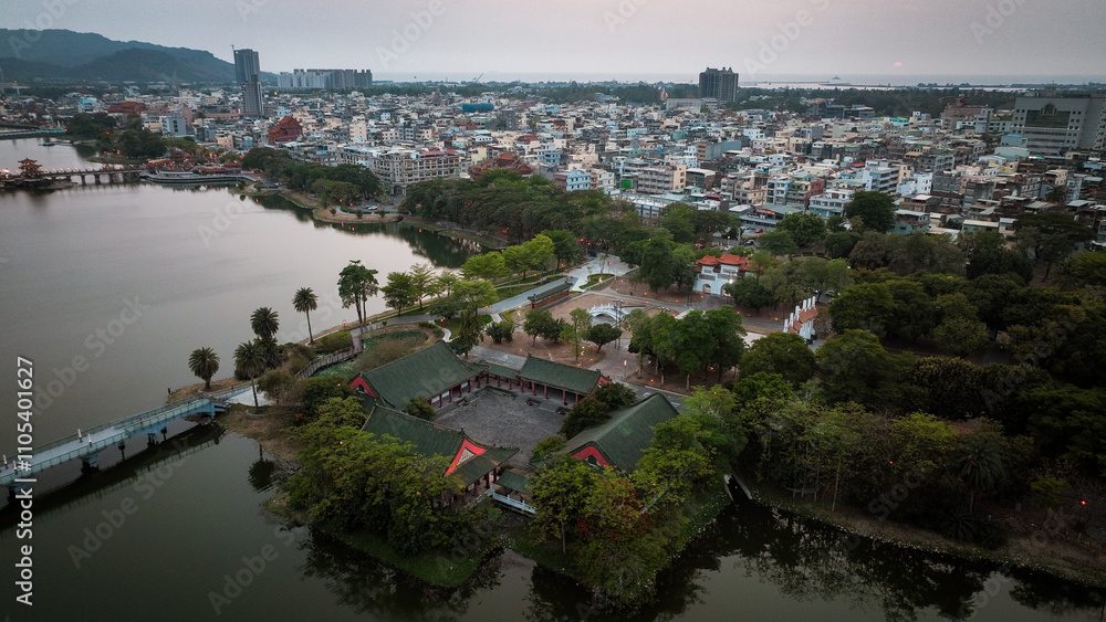 Fototapeta premium Aerial view of lush park and city landscape in Kaohsiung during twilight hours