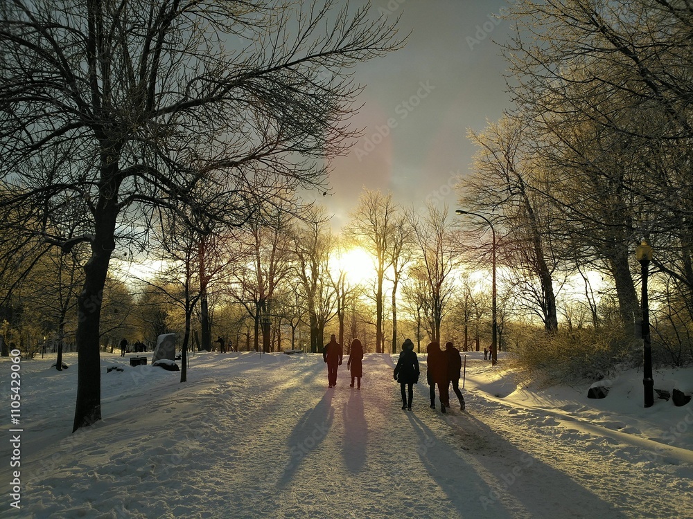 People walking on snowy path at sunset People walking on snowy path at sunset
