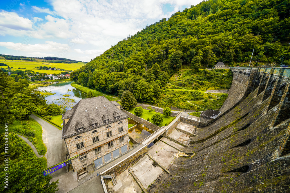 Fototapeta premium Dam wall at Diemelsee and the surrounding landscape. Diemel Dam in Sauerland. Historical building for water supply. 